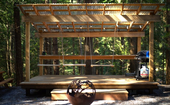 Tall cedar and fir trees surrounding a hand-built cabin at Rocky Valley Resort on Texada Island