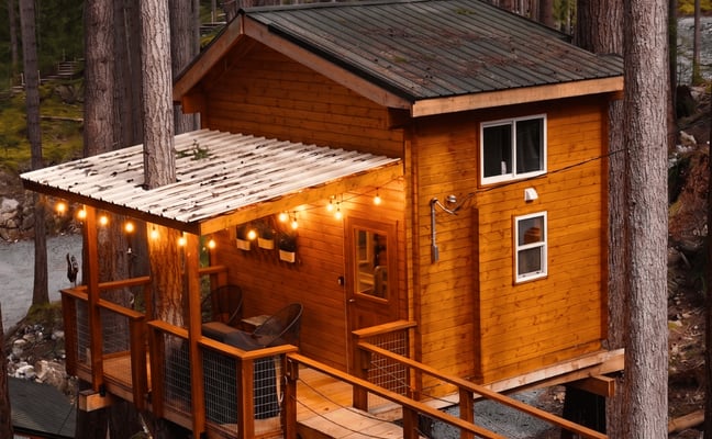 Brian, founder of Rocky Valley Resort, working on a hand-built cabin structure surrounded by forest